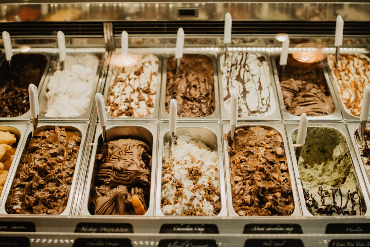 heros-img A close-up view of various gelato flavors in trays at a store.